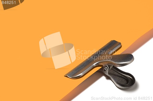 Image of Metallic paperclip on orange paper