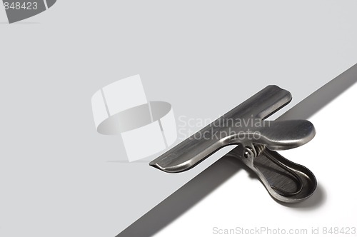 Image of Metallic paperclip on grey paper