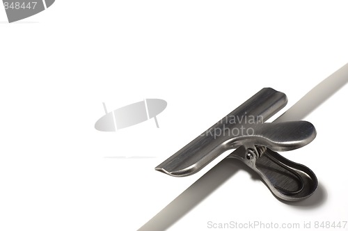 Image of Metallic paperclip on white paper