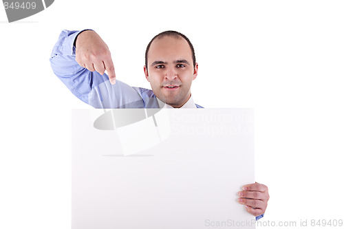 Image of Young businessman holding a whiteboard and pointing, looking at the camera
