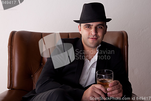 Image of Man with hat seated on a chair