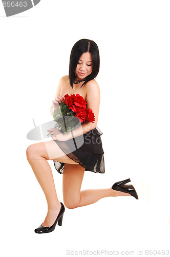 Image of Chinese girl kneeling in black dress.