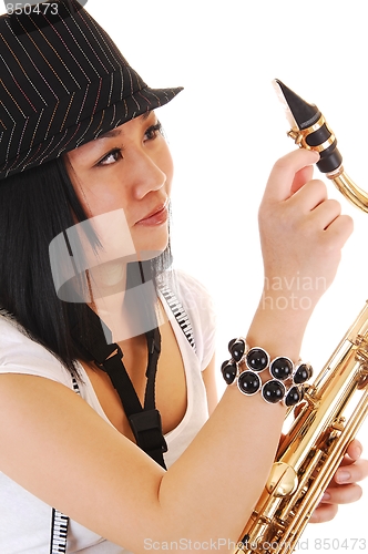 Image of Chinese girl fixing the saxophone.