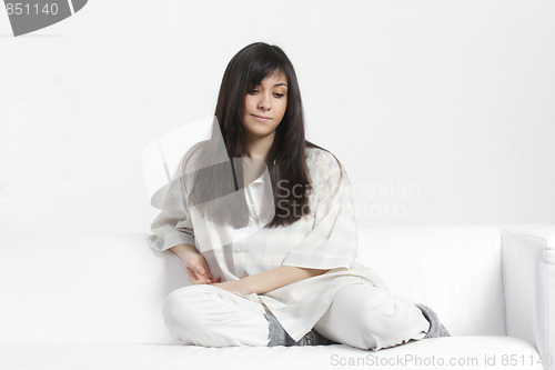 Image of Thoughtful brunette sitting on sofa