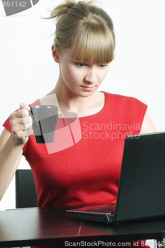 Image of Businesswoman with black cup looking to monitor