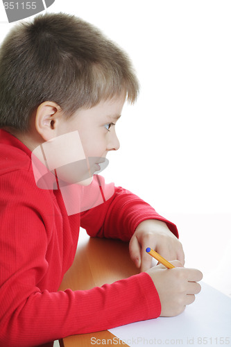 Image of Boy in red writing at desk