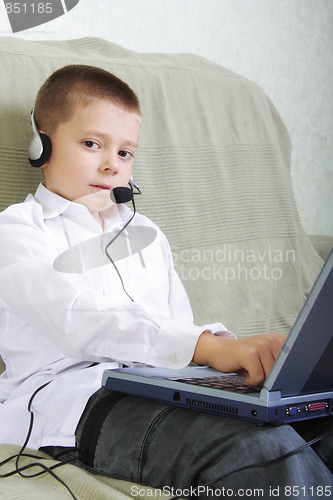 Image of Serene boy in headset working on laptop