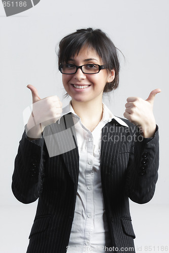 Image of Smiling businesswoman raising thumbs up