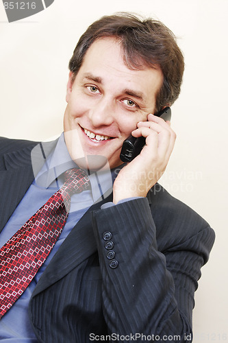 Image of Smiling businessman with phone inclining left