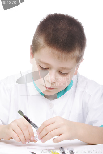 Image of Serious boy with magnifier and tweezers