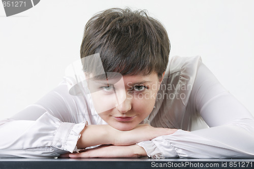 Image of Young woman leaning on table