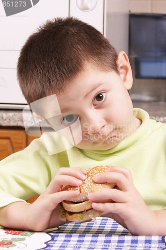 Image of Grimacing boy with hamburger