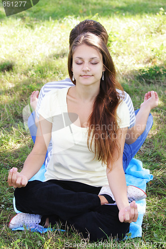 Image of Young woman relaxing in yoga pose