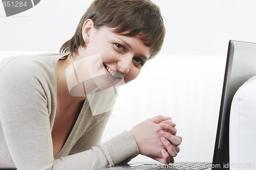 Image of Smiling woman on sofa with computer
