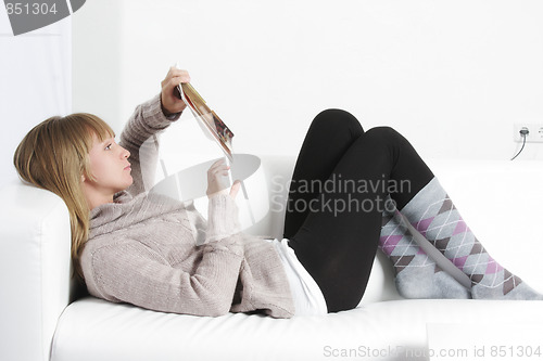 Image of Woman reading book laying on back
