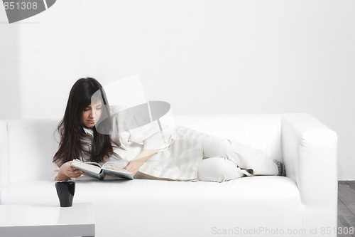 Image of Brunette reading on sofa