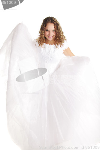 Image of Smiling bride raising dress edges