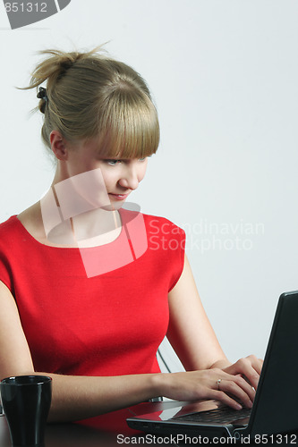 Image of Businesswoman in red working on laptop