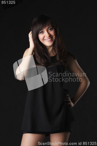 Image of Young positive woman in black short dress