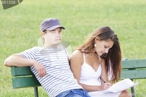 Image of Couple sitting on bench in summer