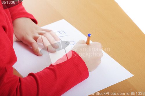 Image of Child hands writing at desk