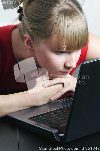 Image of Businesswoman in red looking to monitor