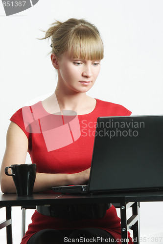 Image of Businesswoman in red typing on laptop