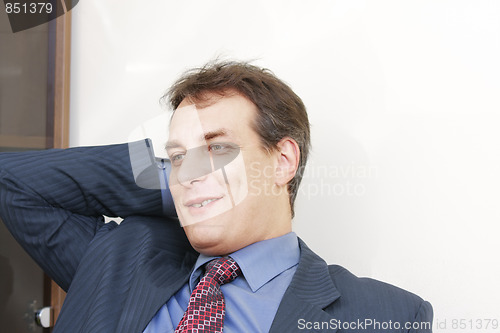 Image of Smiling businessman scratching head