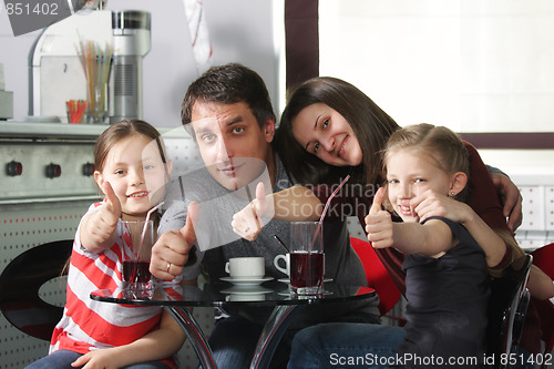 Image of Family in cafe showing thumbs up