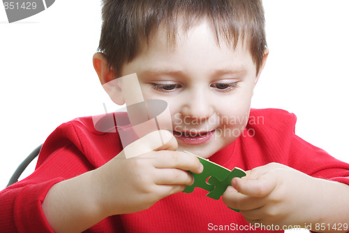 Image of Smiling boy assembling green puzzles