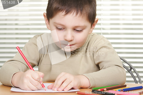Image of Boy drawing with red pencil