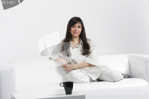 Image of Serene brunette sitting on sofa
