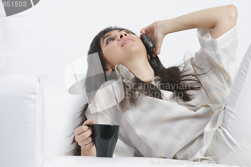 Image of Brunette with phone and black cup
