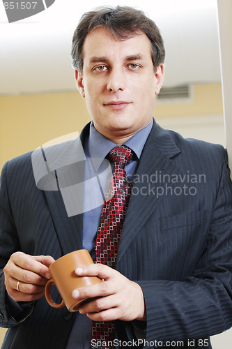 Image of Confident businessman with cup