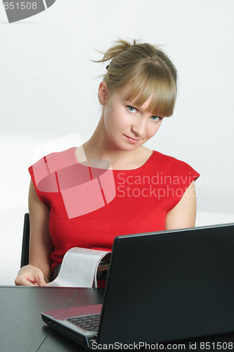 Image of Businesswoman in red holding magazine