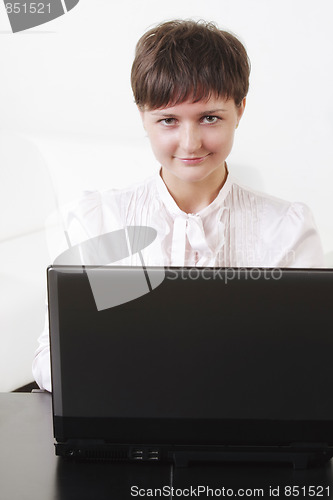 Image of Positive businesswoman behind laptop
