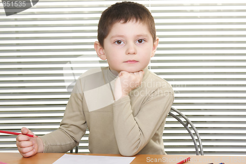 Image of Serious boy leaning on fist