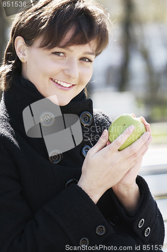Image of Smiling woman in black with apple
