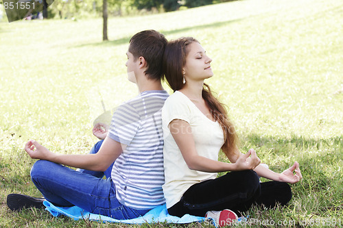 Image of Young couple relaxing in yoga pose