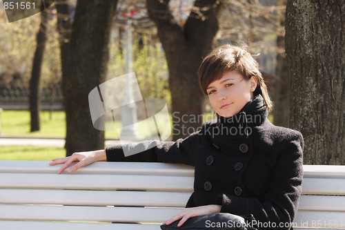 Image of Serene woman in black on bench