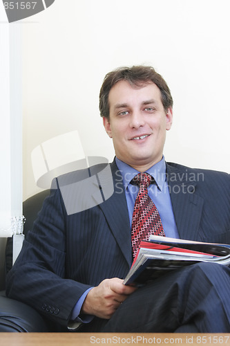 Image of Smiling businessman with magazine