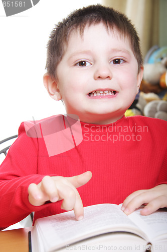 Image of Funny boy in red pointing to book page