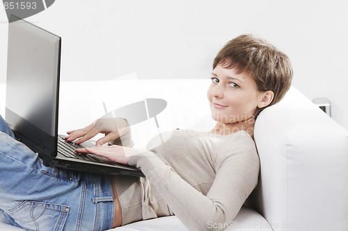 Image of Young woman on sofa with computer