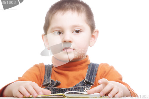 Image of Thoughtful boy sitting with open book