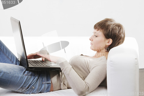 Image of Woman laying on back with laptop
