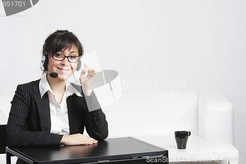 Image of Businesswoman with headset at empty desk