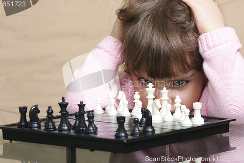 Image of Girl thinking over chess
