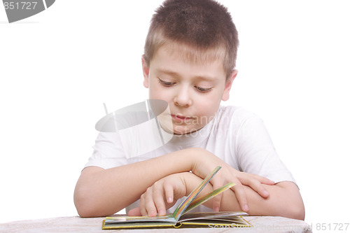 Image of Boy in white shirt reading book