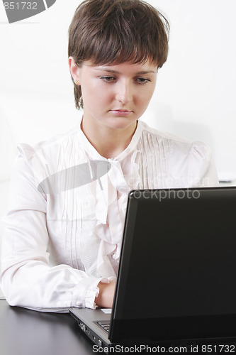 Image of Concentrated businesswoman working on laptop