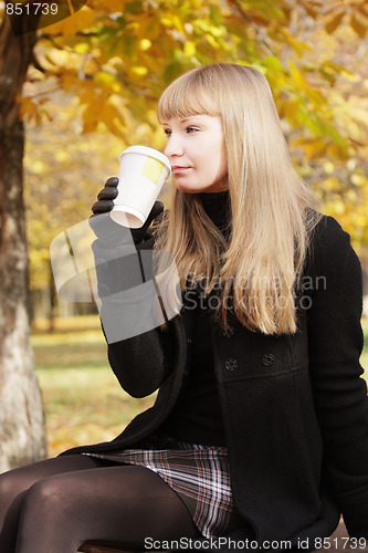 Image of Blonde in black drinking from cup